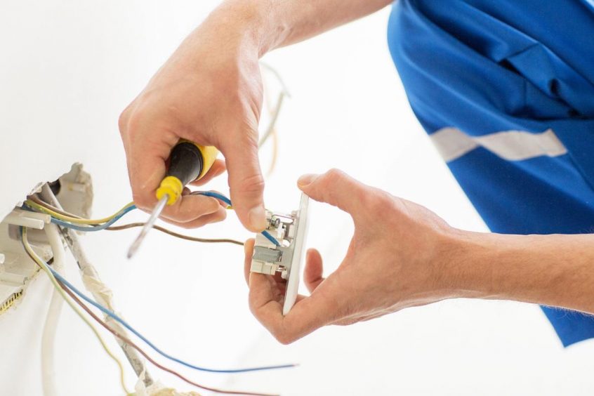 Man fixing electrical outlet